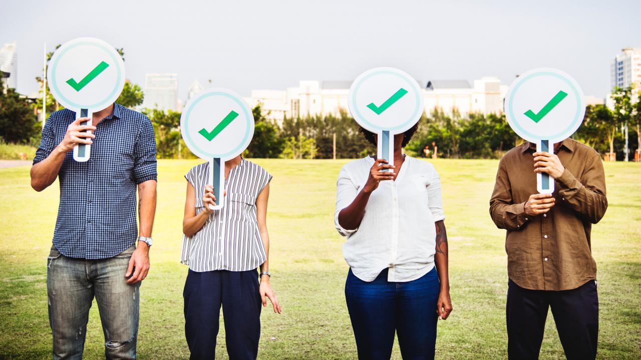 four people holding shields in park